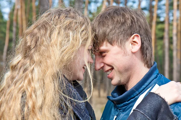 Krásný mladý pár s úsměvem společně v lese — Stock fotografie