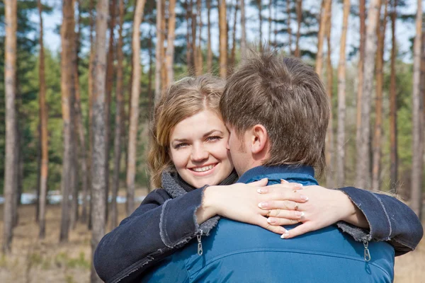 Belo jovem casal sorrindo juntos na floresta — Fotografia de Stock