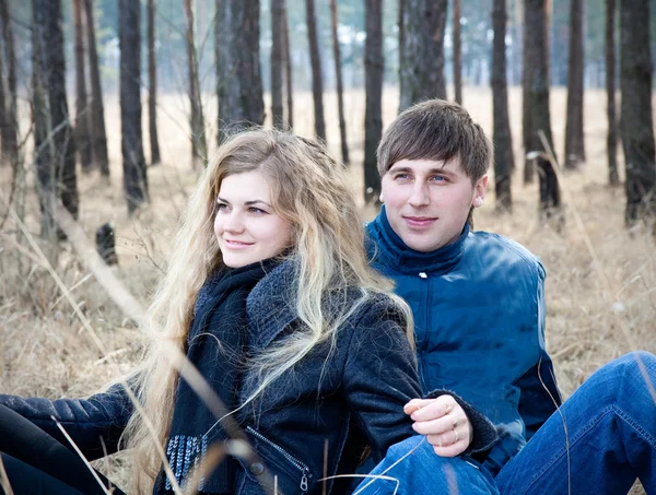 Krásný mladý pár s úsměvem společně v lese — Stock fotografie