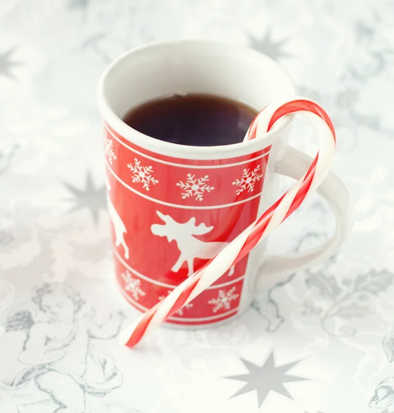 Tea in christmas cup and striped candy — Stock Photo, Image