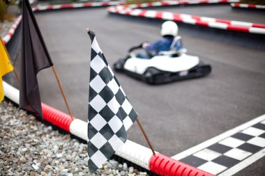Flags and car on carting track clipart