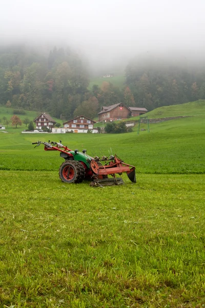 Tractor standing on the sloping field — Stock Photo, Image