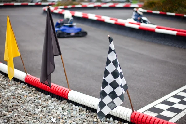 Vlaggen en auto's op karten track — Stockfoto