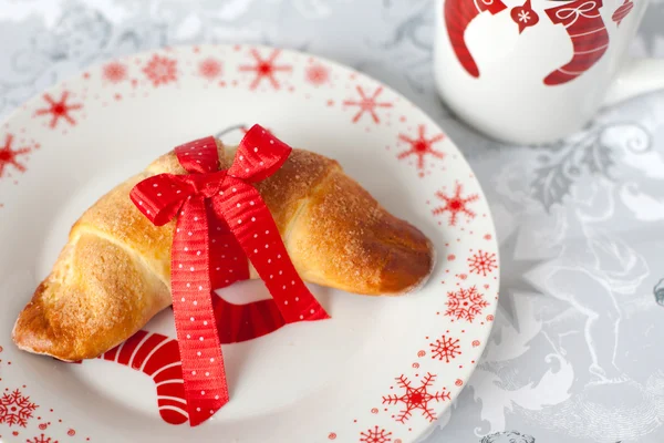 Brioche tied with a red bow on a plate in Christmas style — Stock Photo, Image