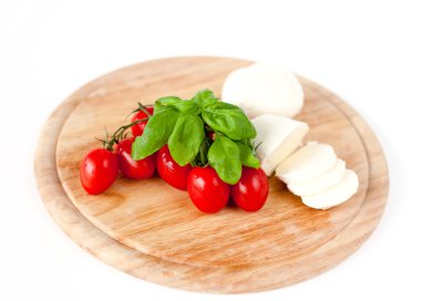 Mozzarella peyniri, domates ve fesleğen ahşap tahta üzerinde