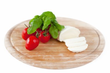 Mozzarella peyniri, domates ve fesleğen ahşap tahta üzerinde