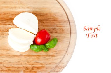 Mozzarella peyniri, domates ve fesleğen ahşap tahta üzerinde