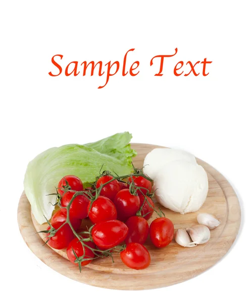 stock image Mozzarella, tomatoes, garlic and salad leaf and basil on wooden board