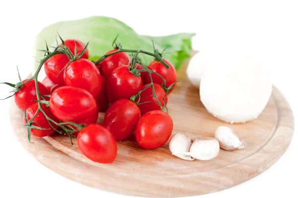 Mozzarella, tomates, ajo y ensalada y albahaca sobre tabla de madera — Foto de Stock