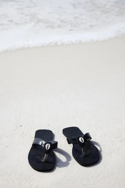 stock image Black flip flops on the beach