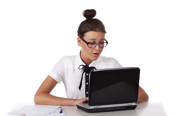 Женщина в очках сидит и работает на ноутбуке — стоковое фото