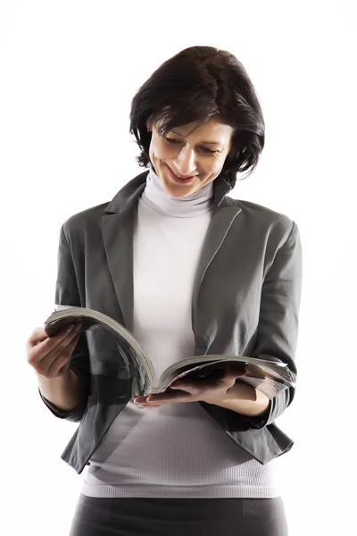Μια γυναίκα διαβάζοντας ένα περιοδικό γυαλιστερό Εικόνα Αρχείου