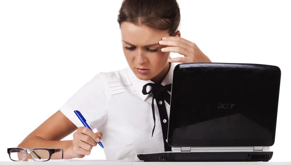 Женщина в очках сидит за столом и работает с ноутбуком — стоковое фото