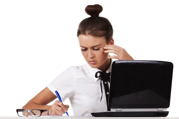 Kobieta w okularach siedzi przy stole i pracy na laptopie — Zdjęcie stockowe