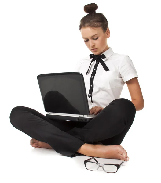 Красивая девушка сидит на полу и работает на ноутбуке — стоковое фото