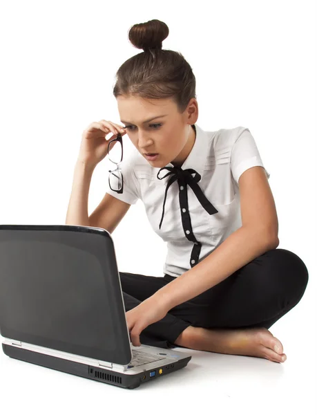 Schönes Mädchen sitzt auf dem Boden und arbeitet an einem Laptop — Stockfoto