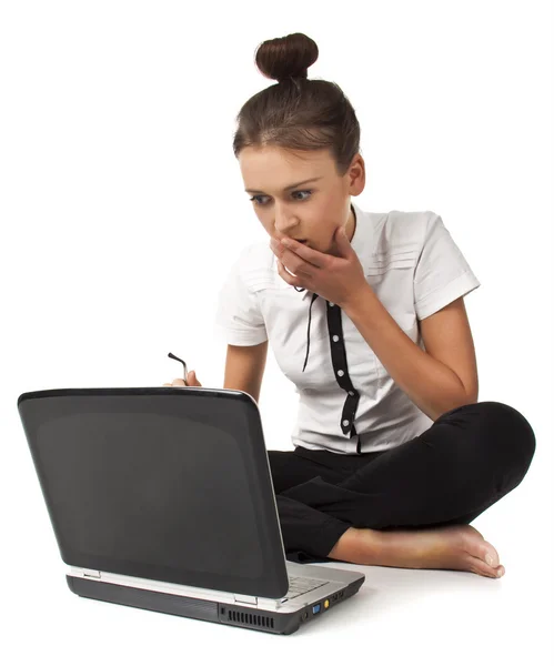 Menina bonita sentada no chão e trabalha em um laptop — Fotografia de Stock