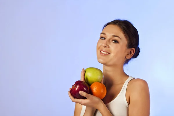 Beautiful brunette holding a fruit apples oranges — Stock Photo, Image
