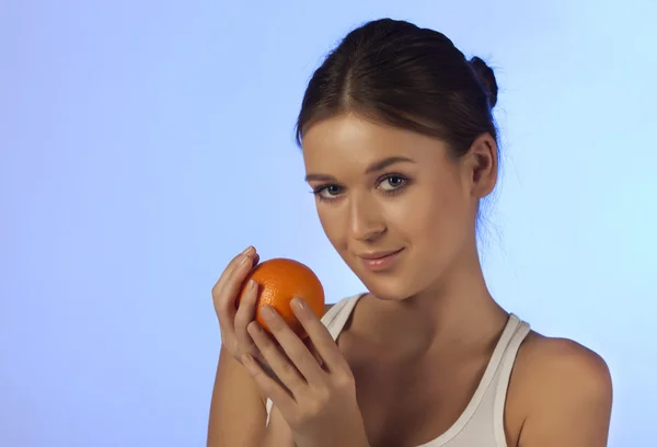 A nő egy narancssárga gyümölcs — Stock Fotó