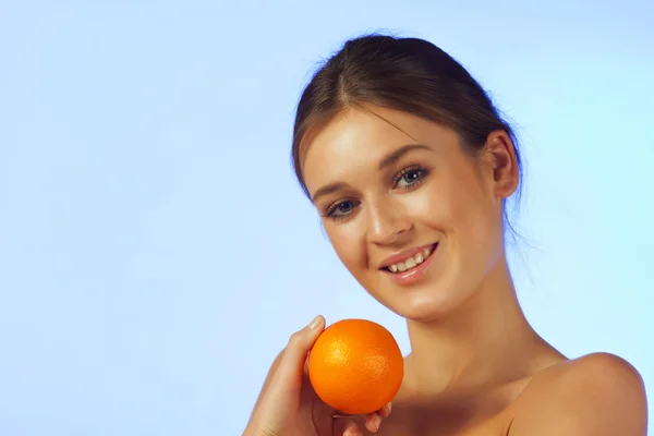 Kvinnan med en orange frukt — Stockfoto