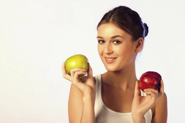 Молода красива брюнетка тримає два яблука — стокове фото