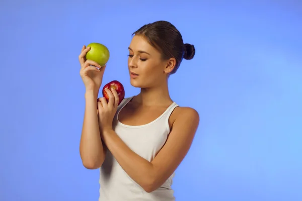 Joven hermosa morena está sosteniendo dos manzanas —  Fotos de Stock