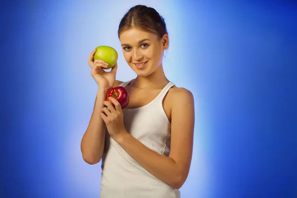 Jovem bela morena está segurando duas maçãs — Fotografia de Stock