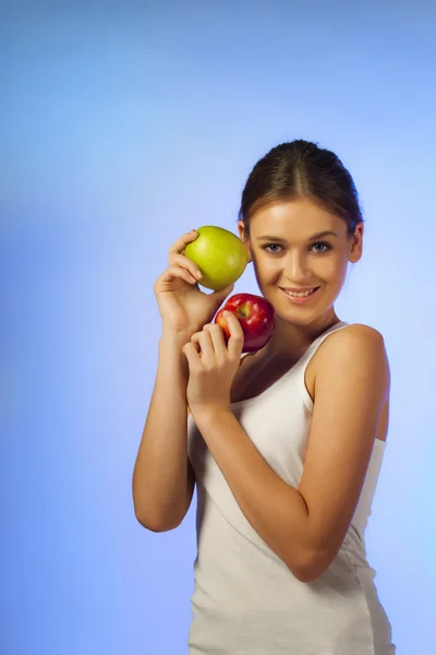 Jovem bela morena está segurando duas maçãs — Fotografia de Stock