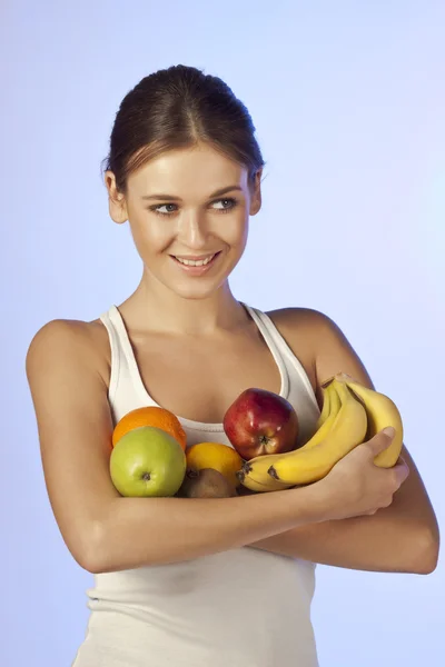 Joven hermosa morena está sosteniendo fruta —  Fotos de Stock
