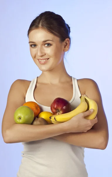 Young beautiful brunette is holding fruit — Stock Photo, Image