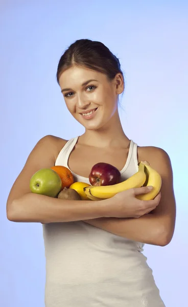 Joven hermosa morena está sosteniendo fruta —  Fotos de Stock