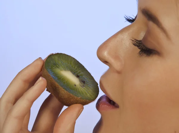 Young woman enjoying a piece of kiwi Stock Picture