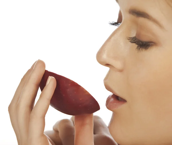 Mladá žena se těší kouskem červené jablko — Stock fotografie