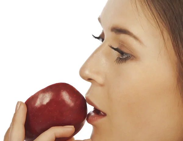 Ung kvinna njuter av en bit av rött äpple — Stockfoto