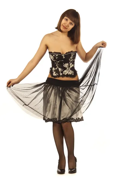 En vuxen kvinna poserar i en kjol, korsett, strumpor, skor — Stockfoto