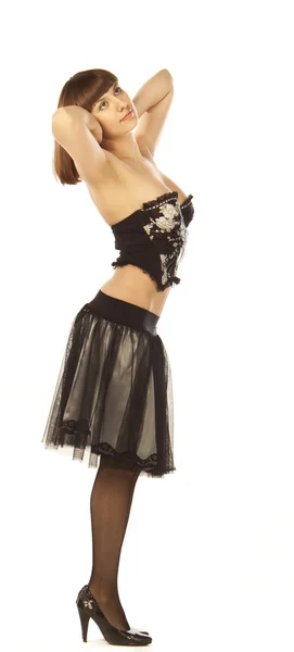 Une femme adulte pose en jupe, corset, jarretelles, chaussure — Photo