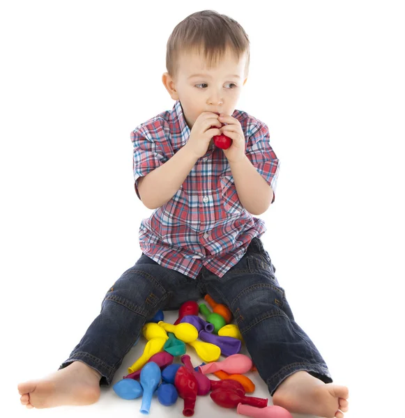 Мальчик играет с надувными мячами цвета — стоковое фото