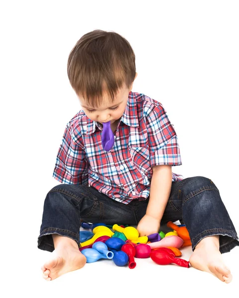 Kleiner Junge spielt mit aufblasbaren bunten Bällen — Stockfoto