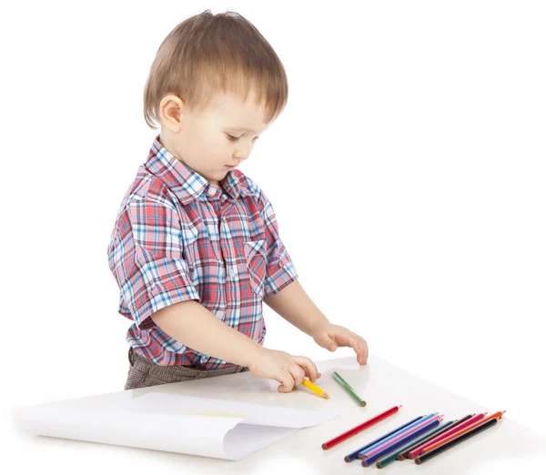 Um menino na mesa desenha com lápis de cor — Fotografia de Stock