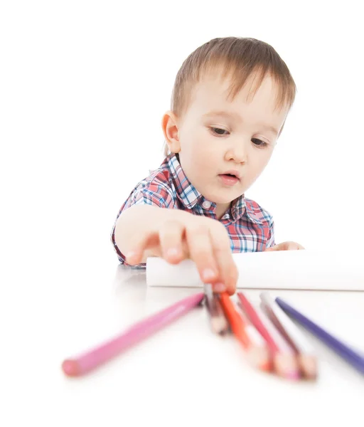 Un niño pequeño en la mesa dibuja con lápices de colores — Foto de Stock
