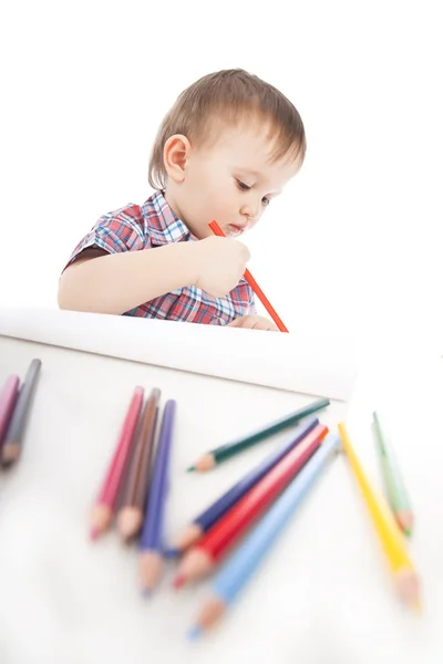 Un petit garçon à la table dessine avec des crayons de couleur — Photo