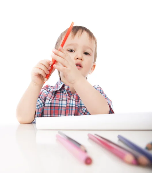 Um menino na mesa desenha com lápis de cor — Fotografia de Stock