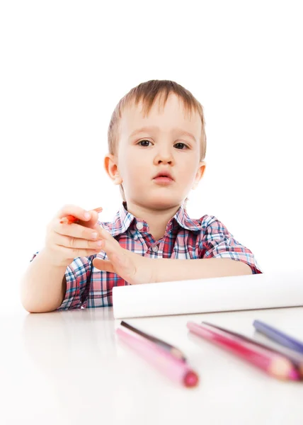 Ένα μικρό αγόρι στο τραπέζι εφιστά με χρωματιστά μολύβια — Φωτογραφία Αρχείου