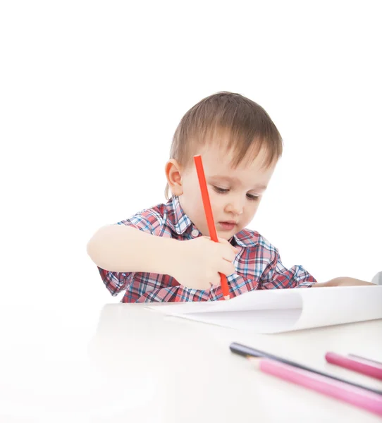 Un niño pequeño en la mesa dibuja con lápices de colores —  Fotos de Stock