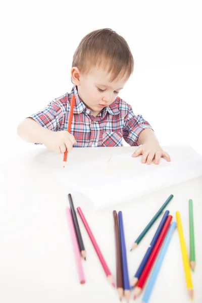 Ένα μικρό αγόρι στο τραπέζι εφιστά με χρωματιστά μολύβια — Φωτογραφία Αρχείου