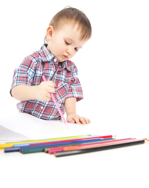 A little boy at the table draws with colored pencils Royalty Free Stock Photos