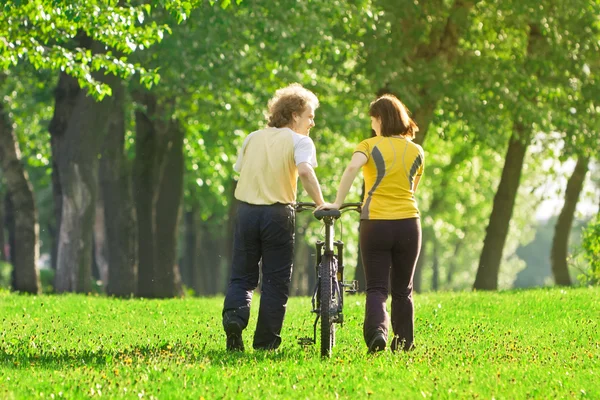 stock image Young couple in the park with a bycicle