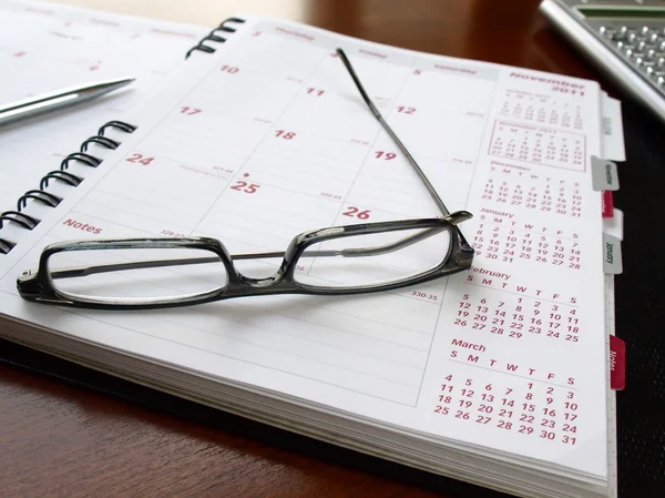 Monatsplaner mit Brille — Stockfoto