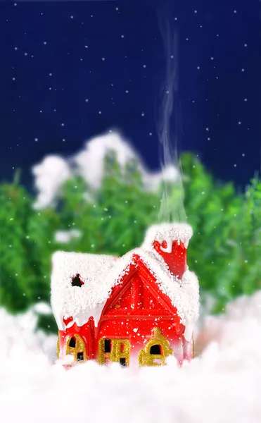 Julkort med ett hus i skogen och snöar — Stockfoto