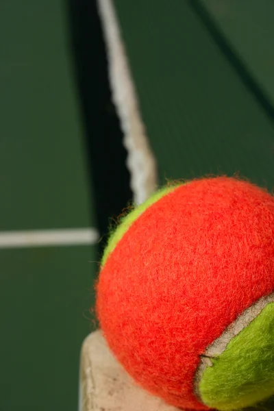 Теннисный мяч на краю сетки — стоковое фото